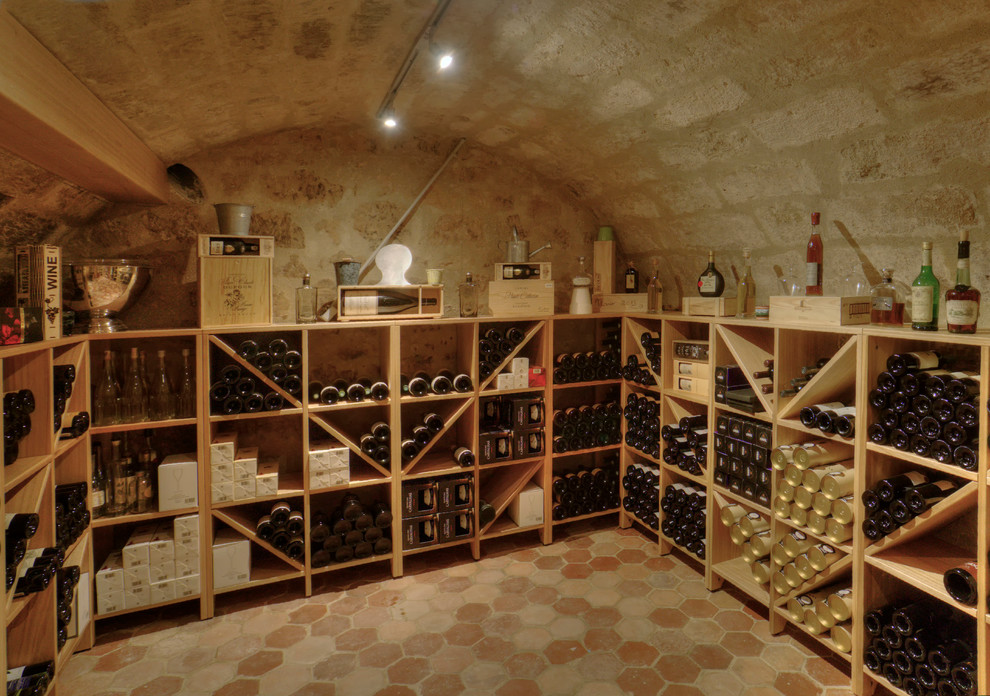 Inspiration för en mellanstor vintage vinkällare, med vinställ med diagonal vinförvaring och klinkergolv i terrakotta