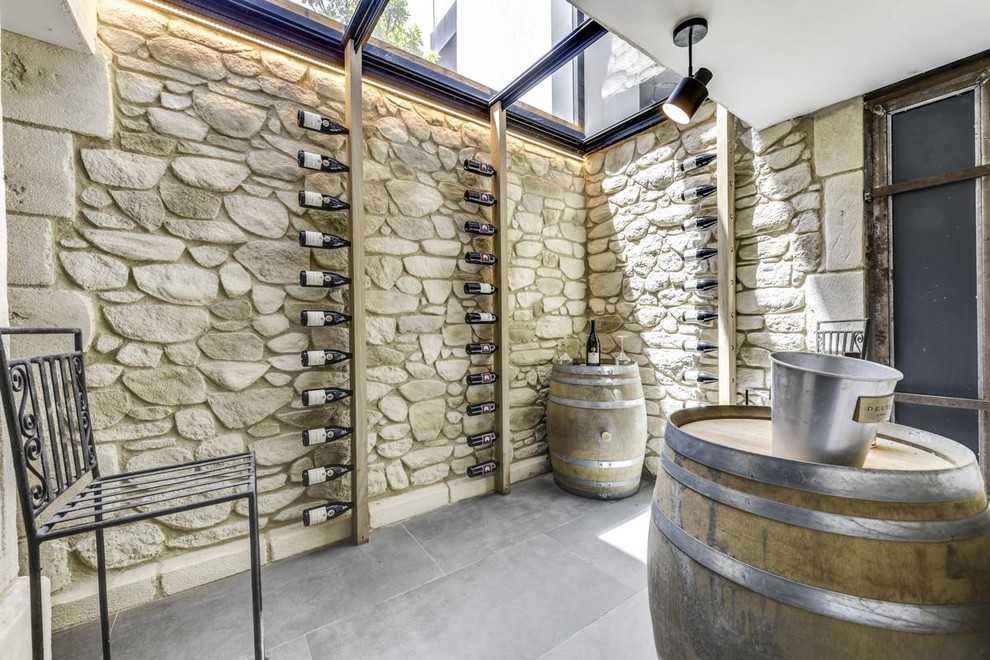 Exemple d'une grande cave à vin méditerranéenne avec sol en béton ciré, un sol gris et un présentoir.