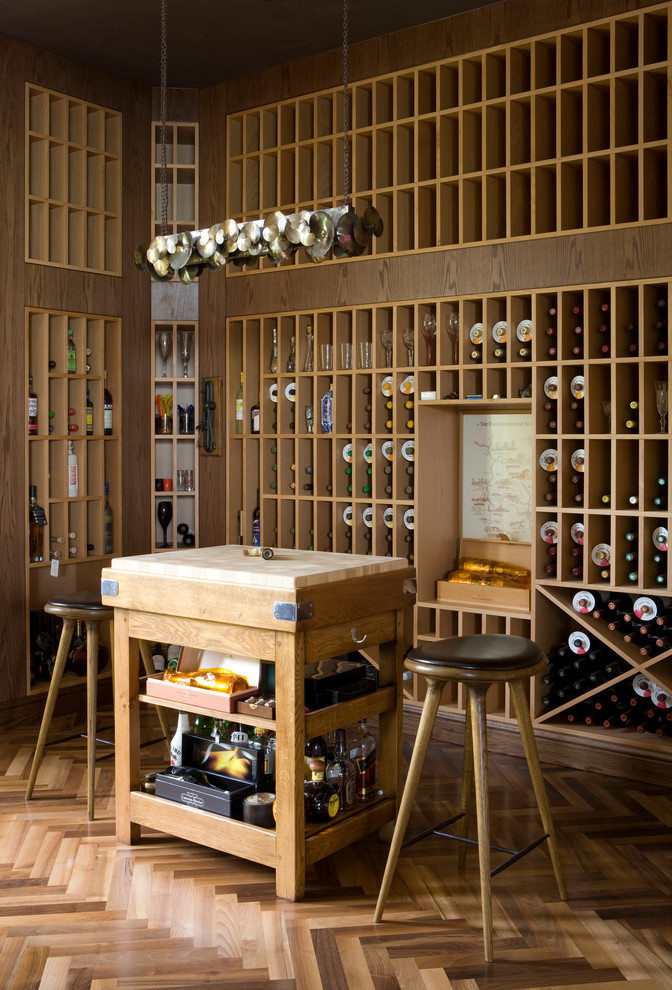 Idée de décoration pour une grande cave à vin design avec un sol en bois brun et des casiers.