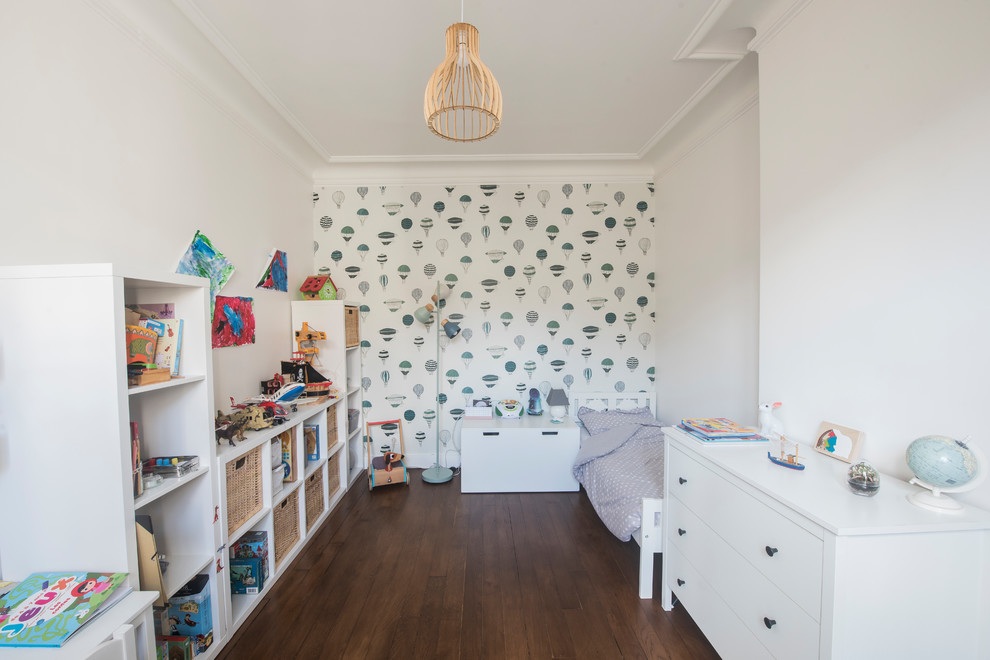 Cette image montre une chambre d'enfant de 4 à 10 ans nordique de taille moyenne avec un mur multicolore, parquet foncé et un sol marron.