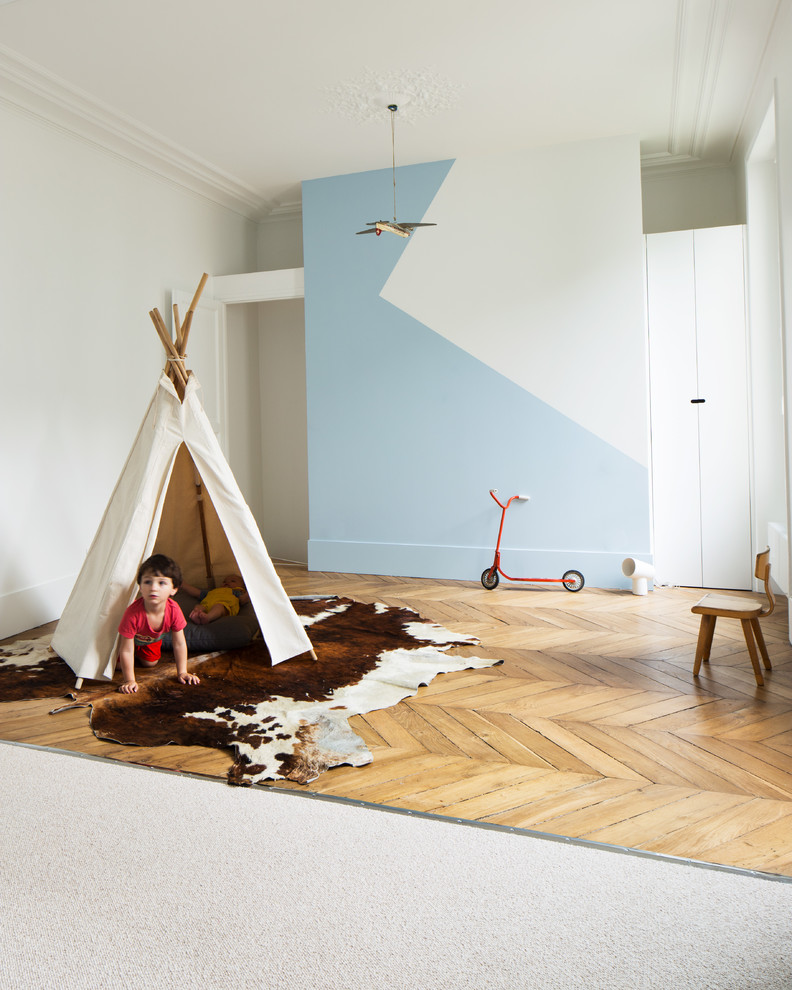 На фото: детская среднего размера в скандинавском стиле с спальным местом, синими стенами и светлым паркетным полом для ребенка от 4 до 10 лет, мальчика