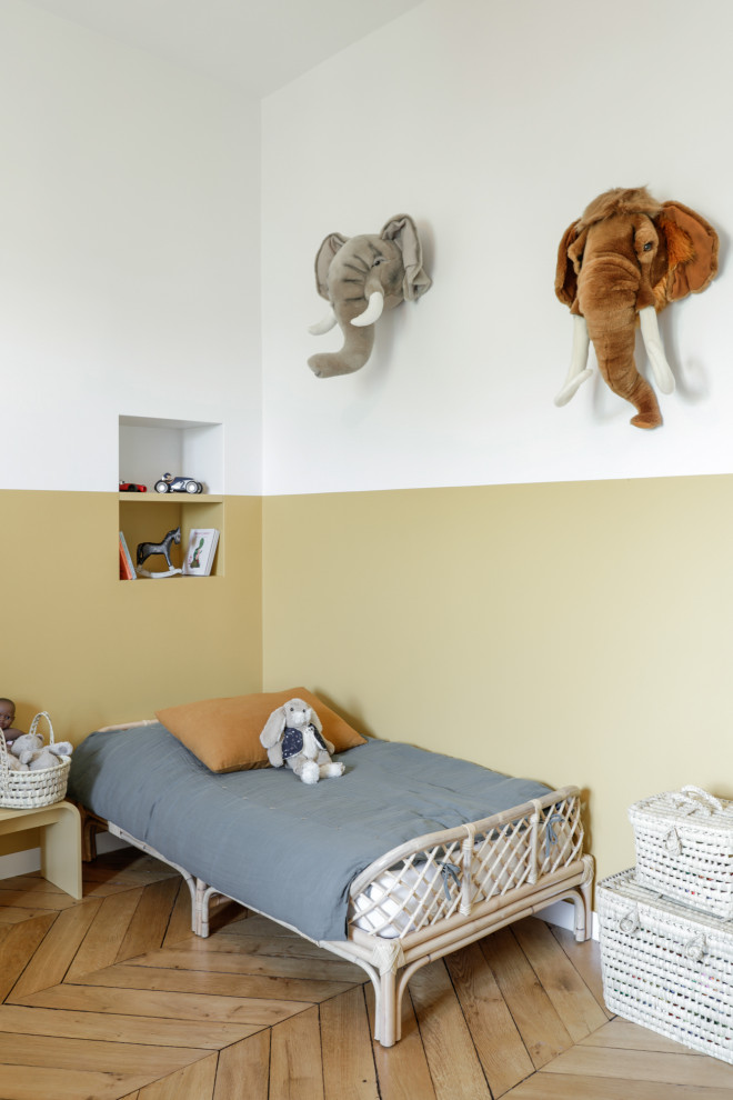 Ispirazione per una cameretta per bambini scandinava con pareti beige, parquet chiaro e pavimento beige