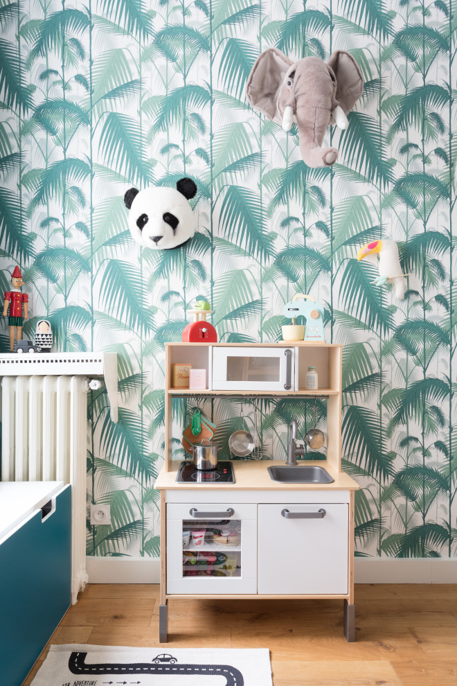 Photo of a medium sized scandinavian children’s room for boys in London with white walls, medium hardwood flooring and brown floors.