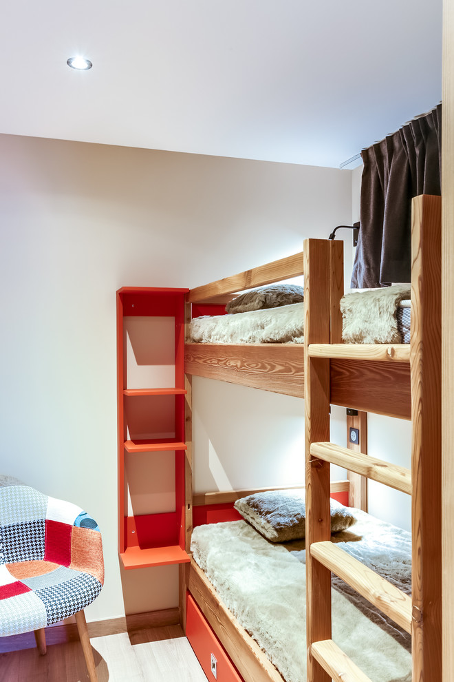 Ejemplo de dormitorio infantil de 4 a 10 años actual de tamaño medio con paredes beige y suelo de madera clara