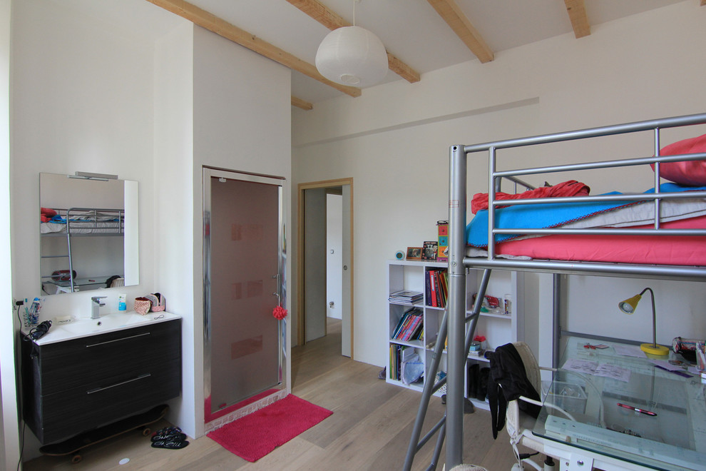 Modelo de dormitorio infantil moderno grande con paredes blancas y suelo de madera clara
