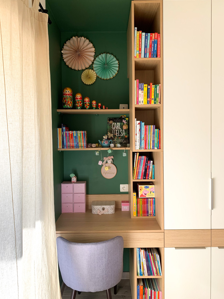 Cette photo montre une chambre d'enfant de 4 à 10 ans moderne de taille moyenne avec un mur vert, sol en stratifié, un sol beige et du papier peint.