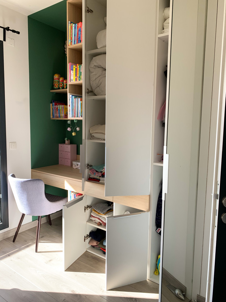 Idée de décoration pour une chambre d'enfant de 4 à 10 ans minimaliste de taille moyenne avec un mur vert, sol en stratifié, un sol beige et du papier peint.