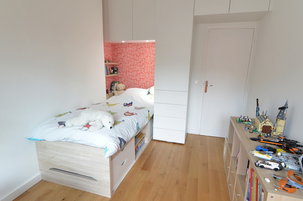 Idéer för att renovera ett mellanstort funkis pojkrum kombinerat med sovrum, med röda väggar och ljust trägolv