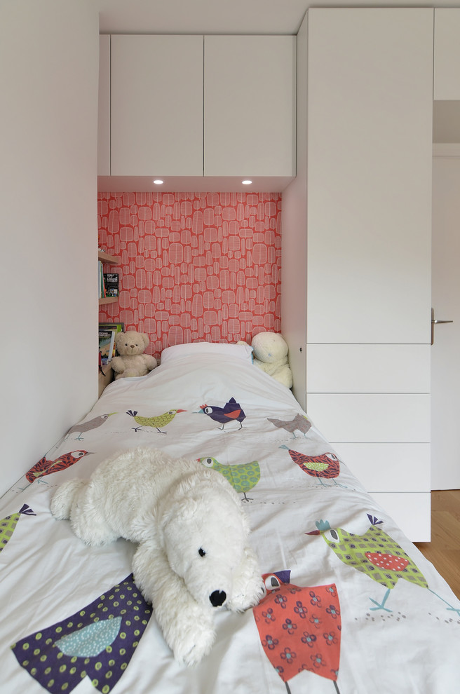 Bild på ett mellanstort funkis pojkrum kombinerat med sovrum, med röda väggar och ljust trägolv