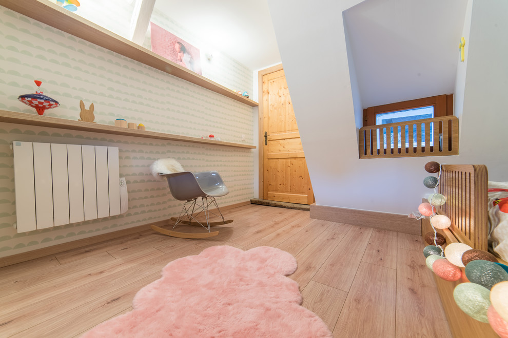 На фото: маленькая детская в скандинавском стиле с спальным местом, синими стенами и полом из ламината для на участке и в саду, девочки с