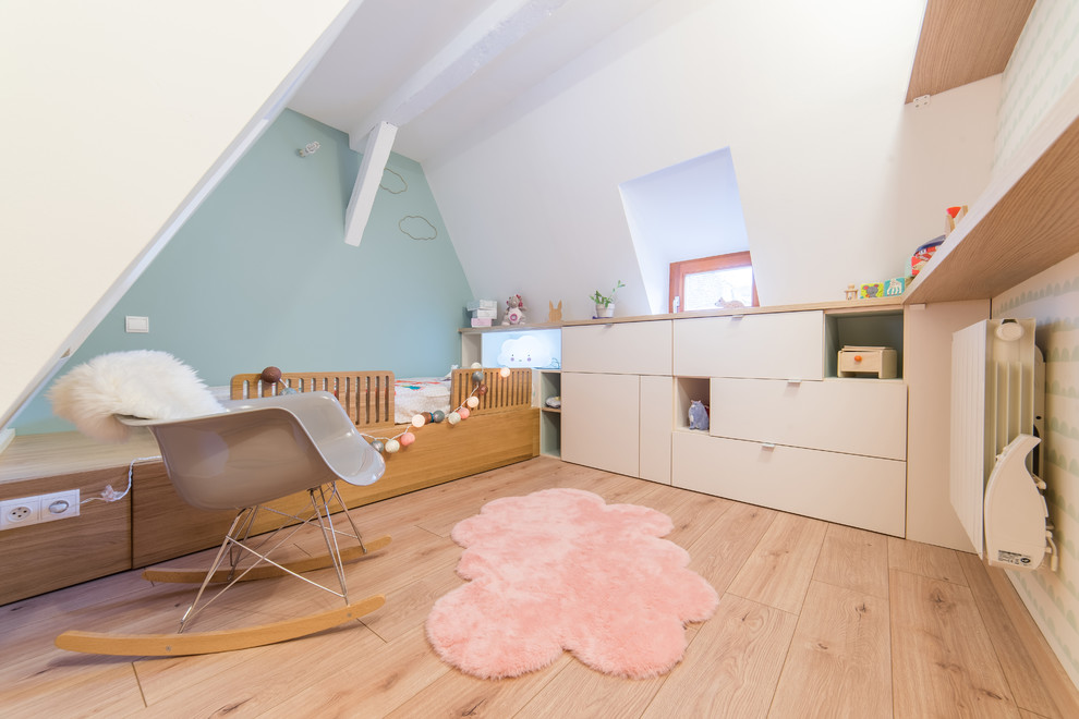 Réalisation d'une petite chambre d'enfant nordique avec un mur bleu et sol en stratifié.