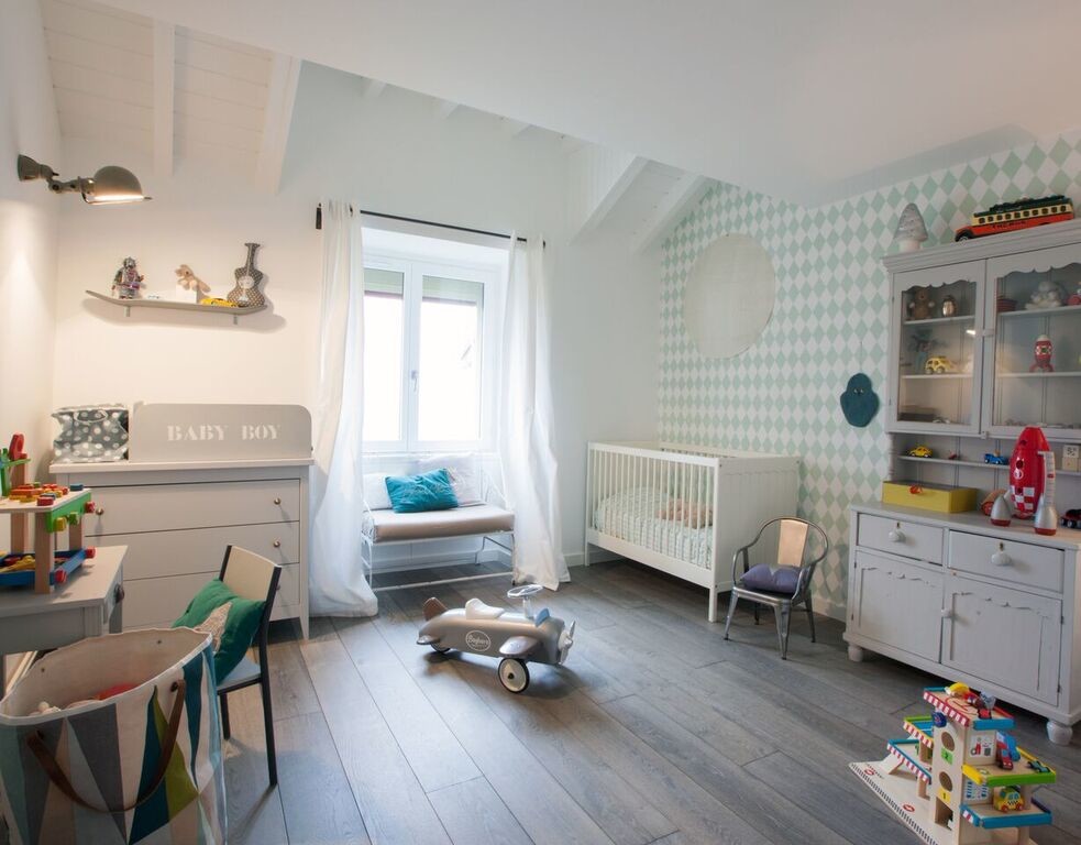 Exemple d'une grande chambre d'enfant de 1 à 3 ans industrielle avec un mur blanc, parquet clair et un sol marron.