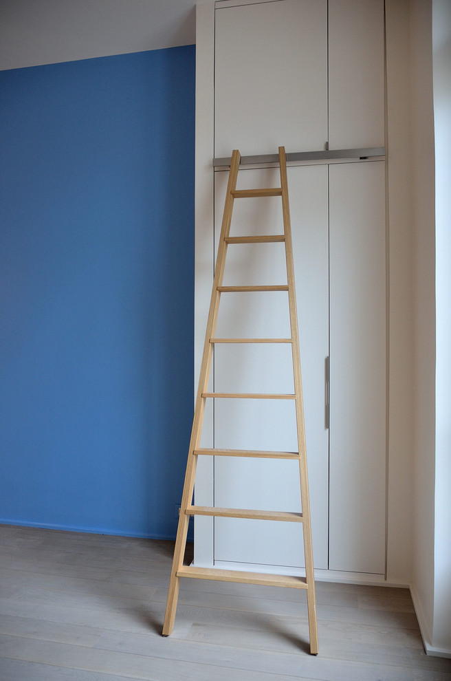 Aménagement d'une chambre d'enfant contemporaine de taille moyenne avec un mur bleu, parquet clair et un sol gris.