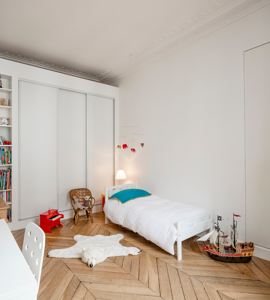 Foto på ett mellanstort nordiskt könsneutralt barnrum kombinerat med sovrum och för 4-10-åringar, med vita väggar, ljust trägolv och beiget golv