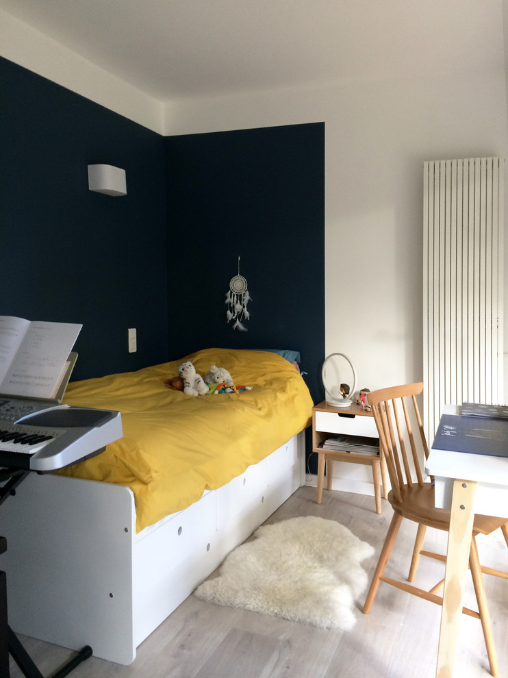 Réalisation d'une chambre d'enfant nordique avec un mur bleu, sol en stratifié et un sol beige.