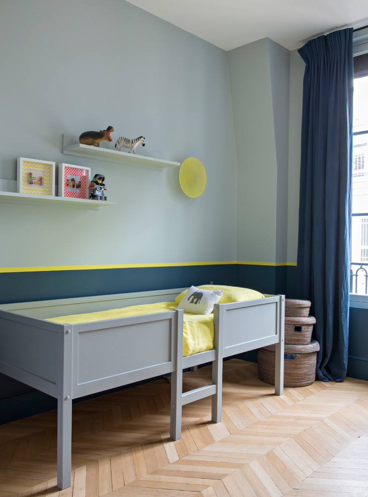 Idee per una cameretta per bambini contemporanea con pareti blu, pavimento in legno massello medio e pavimento marrone