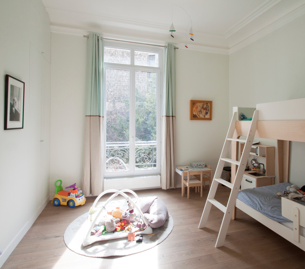 Идея дизайна: нейтральная детская среднего размера в современном стиле с белыми стенами, паркетным полом среднего тона и спальным местом