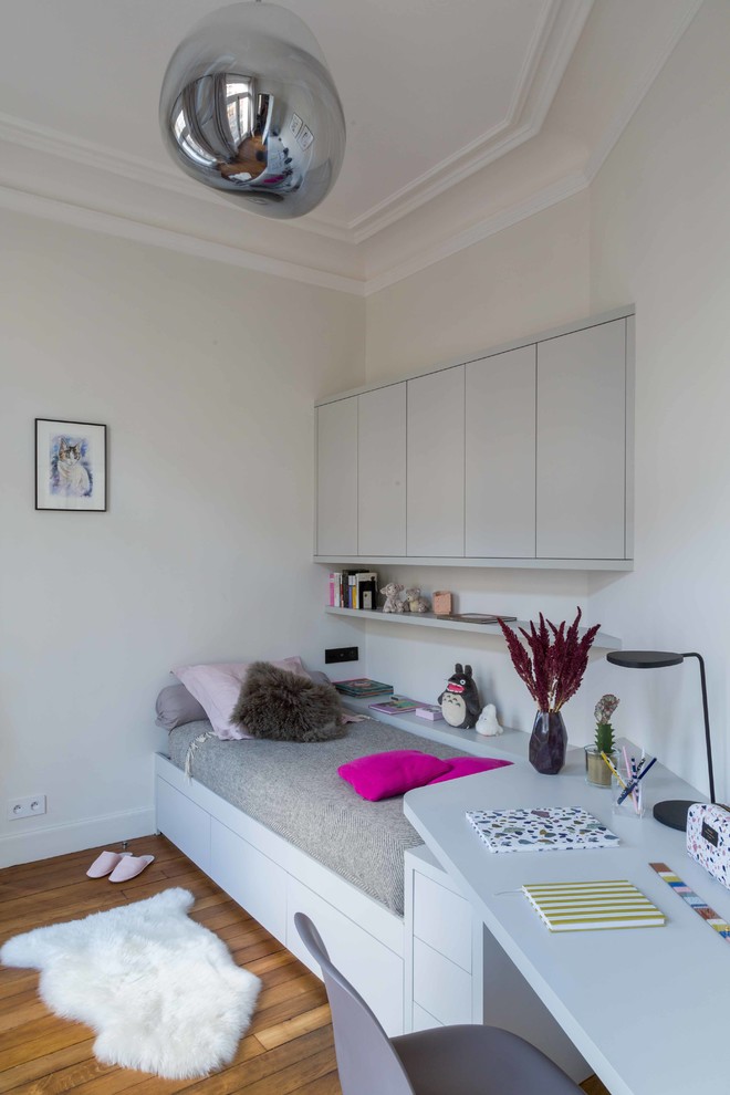 Ispirazione per una cameretta per bambini minimal di medie dimensioni con pareti bianche, parquet chiaro e pavimento marrone