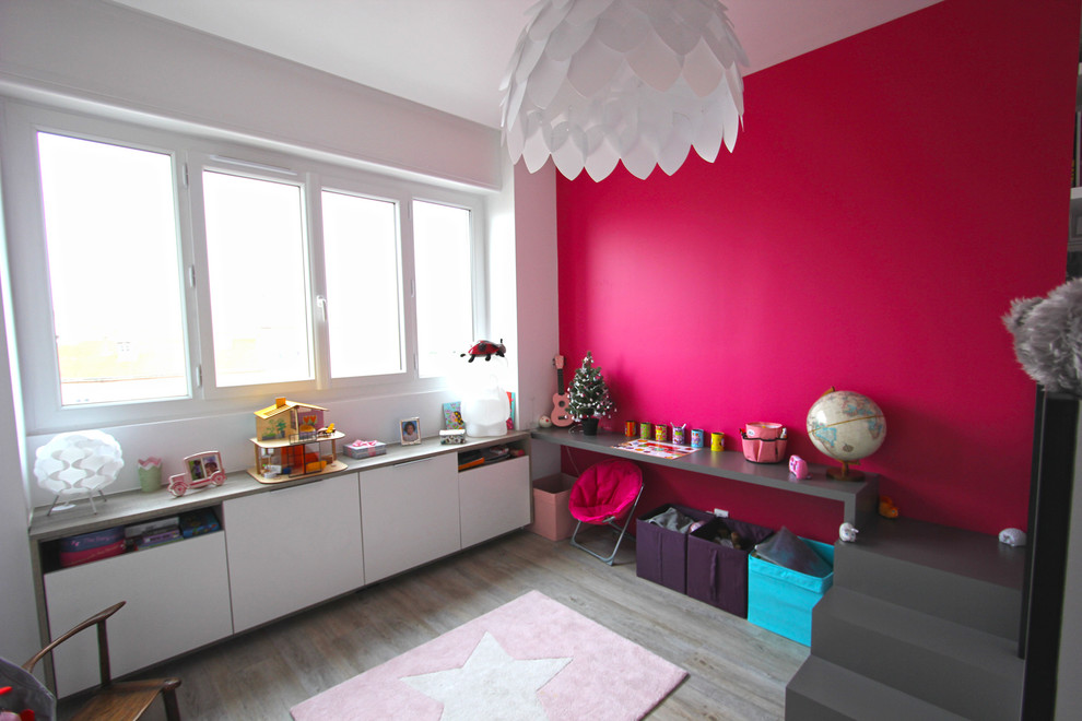 Bild på ett mellanstort funkis flickrum kombinerat med sovrum och för 4-10-åringar, med röda väggar, laminatgolv och grått golv