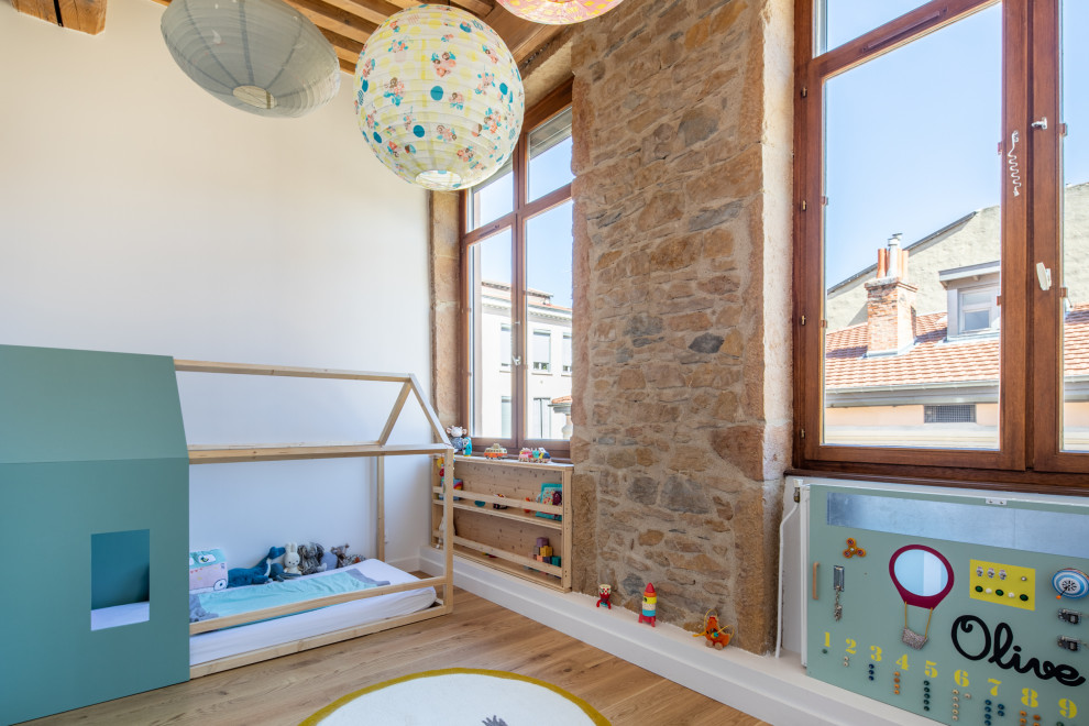 Modelo de dormitorio infantil escandinavo con paredes blancas, suelo de madera en tonos medios, suelo marrón y vigas vistas