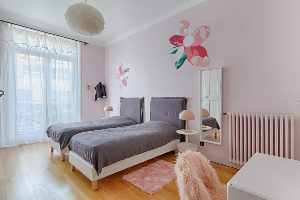 Inspiration för minimalistiska flickrum kombinerat med sovrum och för 4-10-åringar, med rosa väggar och mellanmörkt trägolv