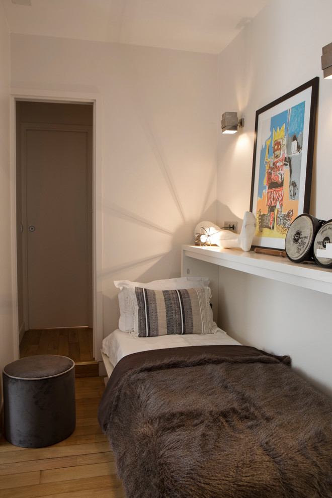 Aménagement d'une petite chambre d'enfant classique avec un mur beige, parquet clair et un sol marron.