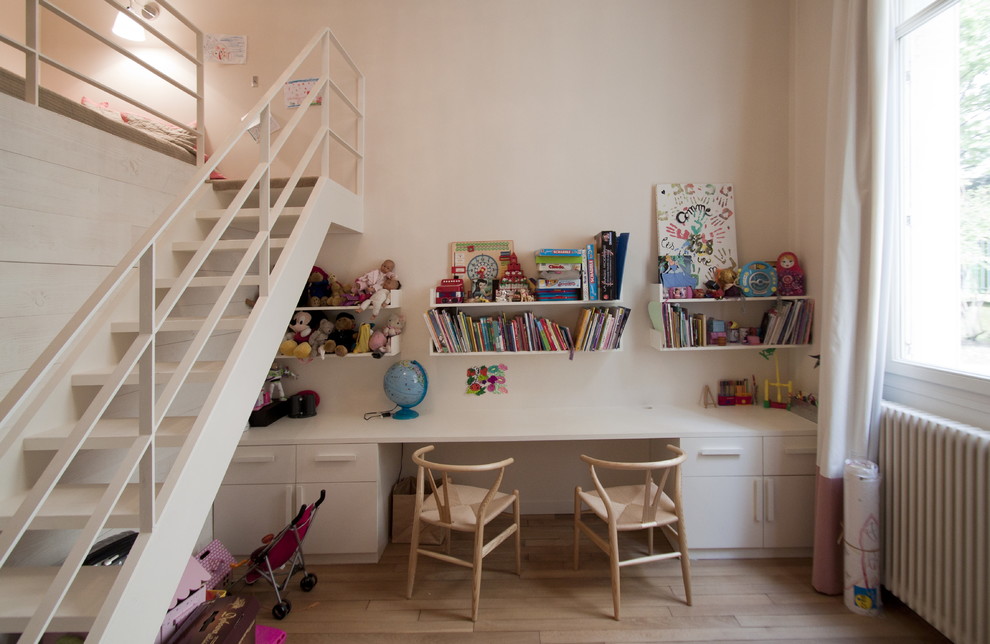 Design ideas for a contemporary gender neutral children’s room in Paris with white walls and light hardwood flooring.