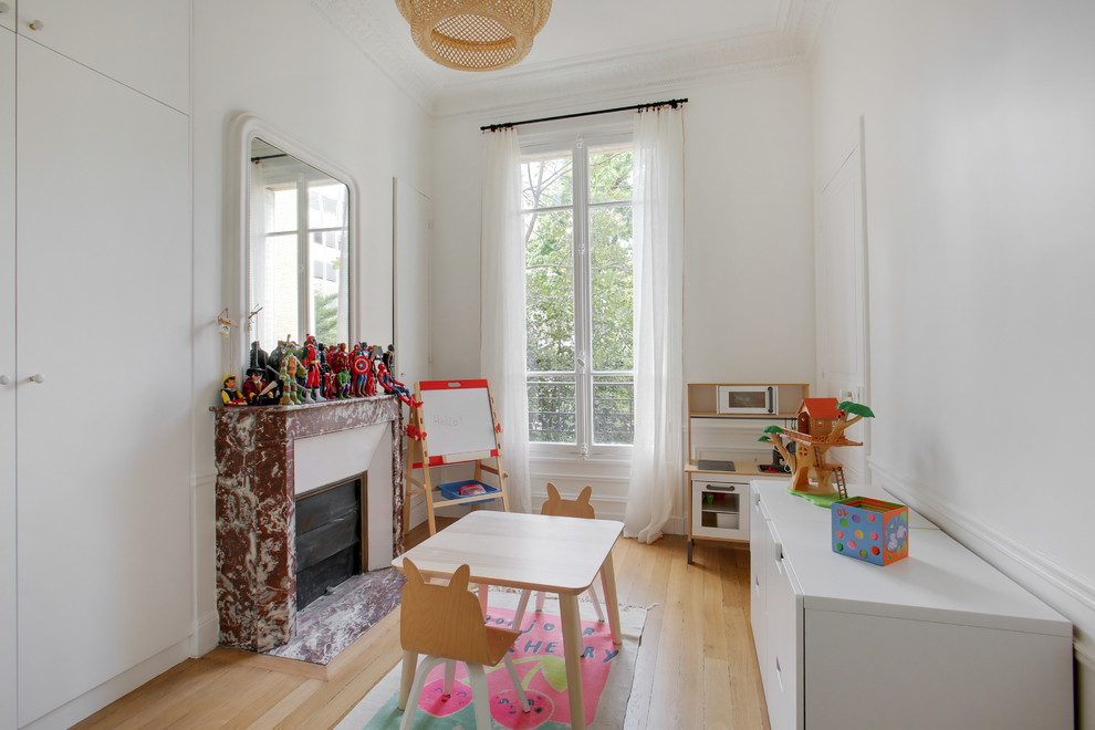 Idéer för ett mellanstort klassiskt könsneutralt barnrum kombinerat med lekrum och för 4-10-åringar, med vita väggar, ljust trägolv och beiget golv
