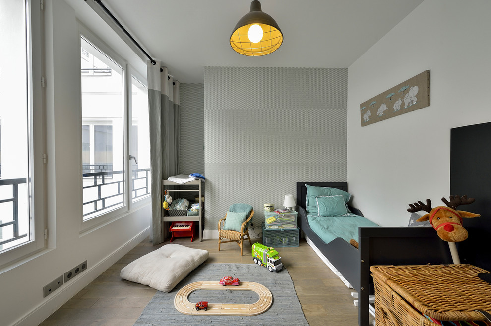 Cette photo montre une chambre d'enfant de 4 à 10 ans chic de taille moyenne avec un mur gris et un sol en bois brun.