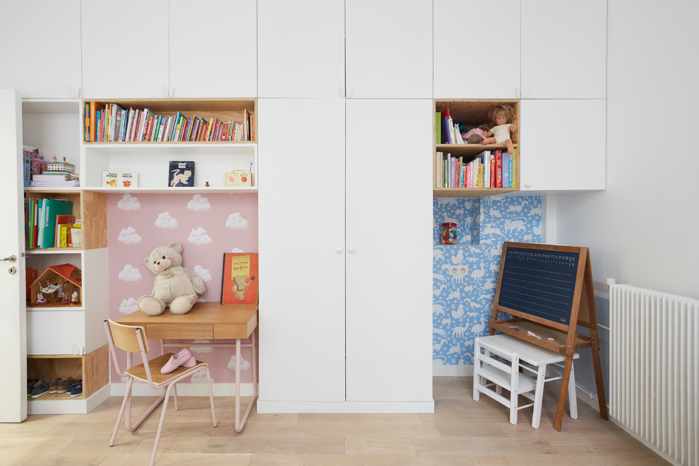 Inredning av ett modernt könsneutralt småbarnsrum kombinerat med skrivbord, med flerfärgade väggar och ljust trägolv