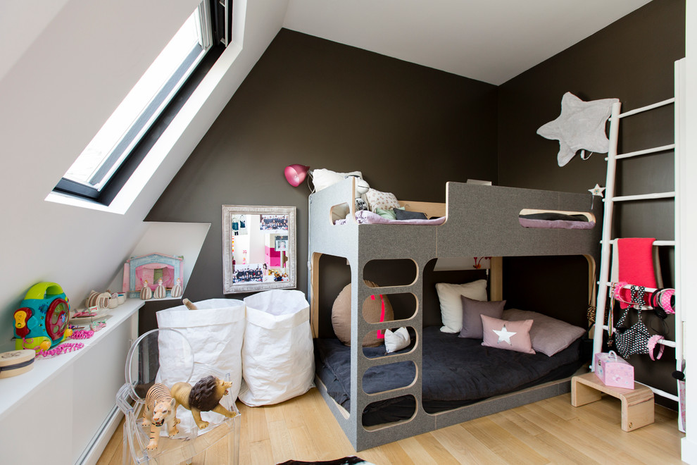 На фото: нейтральная детская среднего размера в скандинавском стиле с спальным местом, светлым паркетным полом и черными стенами для ребенка от 4 до 10 лет с