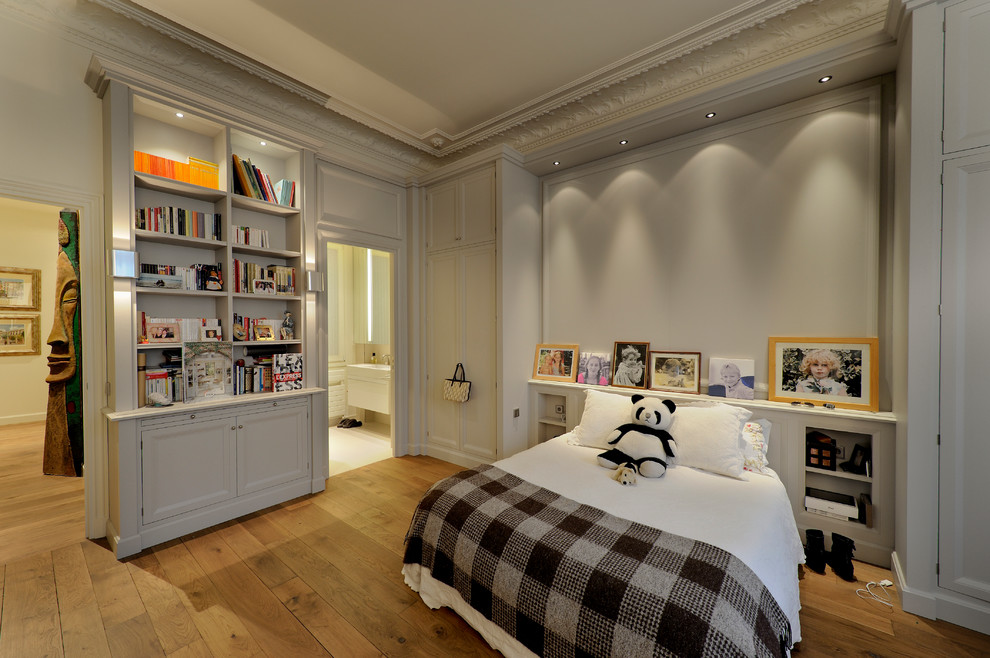 Ejemplo de dormitorio infantil actual grande con paredes beige y suelo de madera en tonos medios