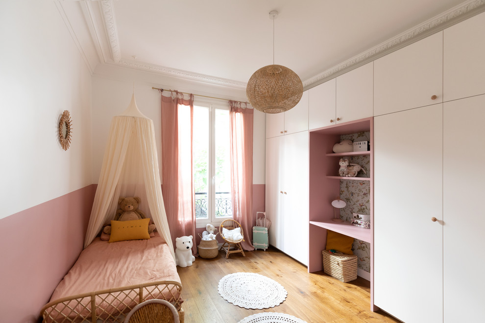 Imagen de dormitorio infantil de 4 a 10 años contemporáneo de tamaño medio con paredes rosas, suelo de madera oscura y suelo marrón