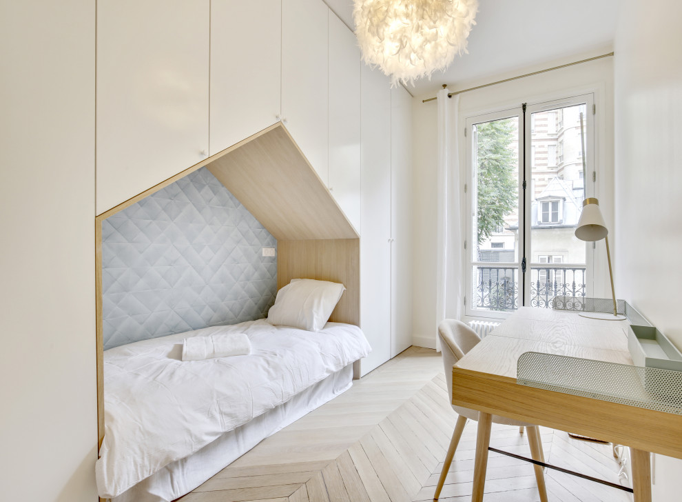 This is an example of a large contemporary gender neutral kids' bedroom in Paris with white walls, light hardwood flooring and beige floors.