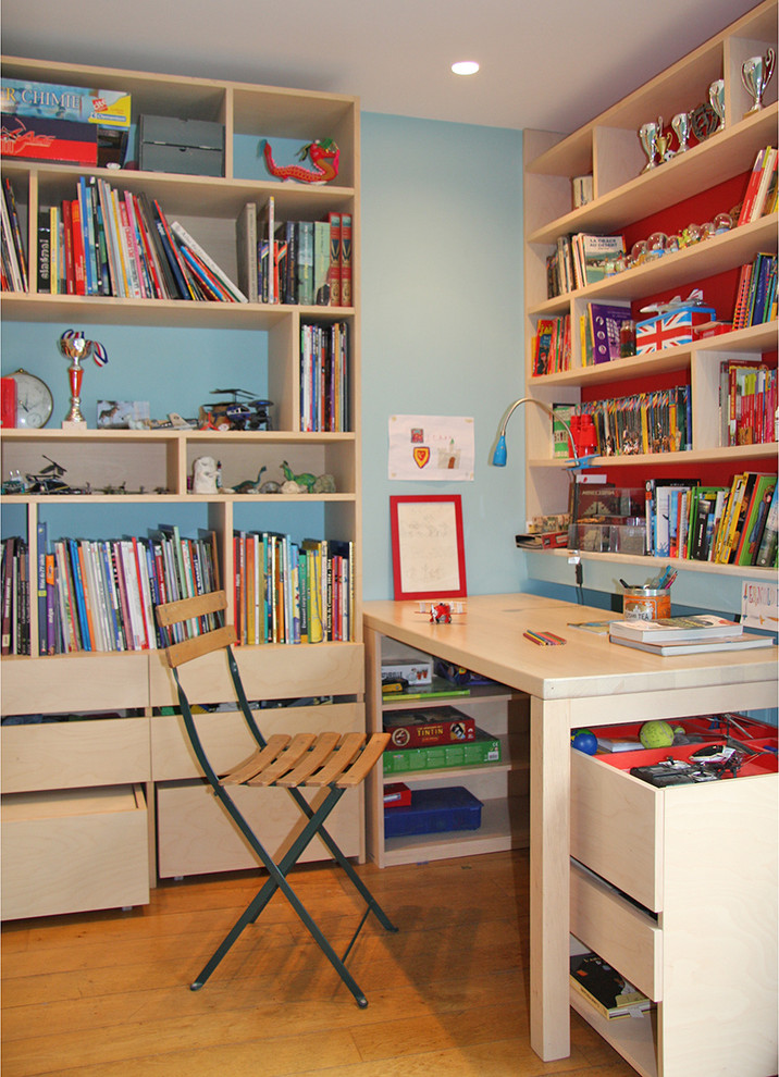 Immagine di una piccola cameretta per bambini da 4 a 10 anni design con pareti blu, parquet chiaro e pavimento marrone