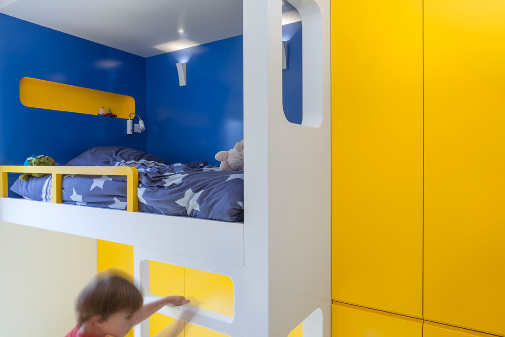 Inspiration för ett mellanstort funkis pojkrum kombinerat med skrivbord och för 4-10-åringar, med blå väggar, målat trägolv och flerfärgat golv