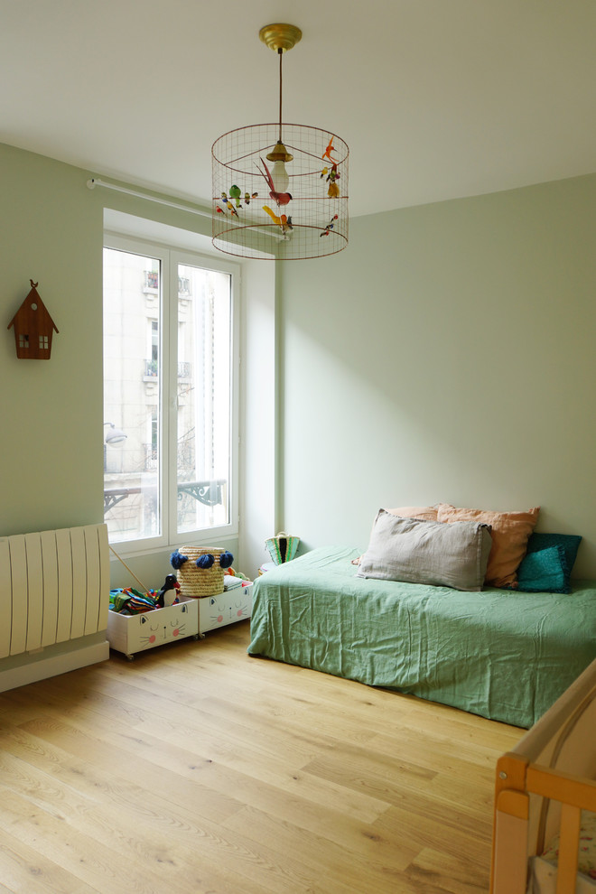 Foto di una cameretta per bambini da 4 a 10 anni minimal di medie dimensioni con pareti verdi, parquet chiaro e pavimento marrone