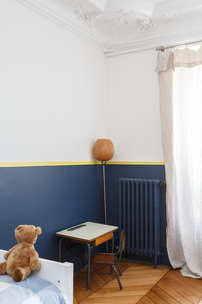 Ispirazione per una cameretta per bambini da 4 a 10 anni contemporanea di medie dimensioni con pareti blu, parquet chiaro e pavimento beige