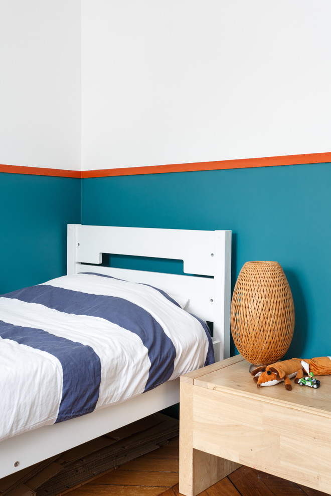 Exemple d'une chambre d'enfant de 1 à 3 ans tendance avec un mur multicolore et un sol en bois brun.