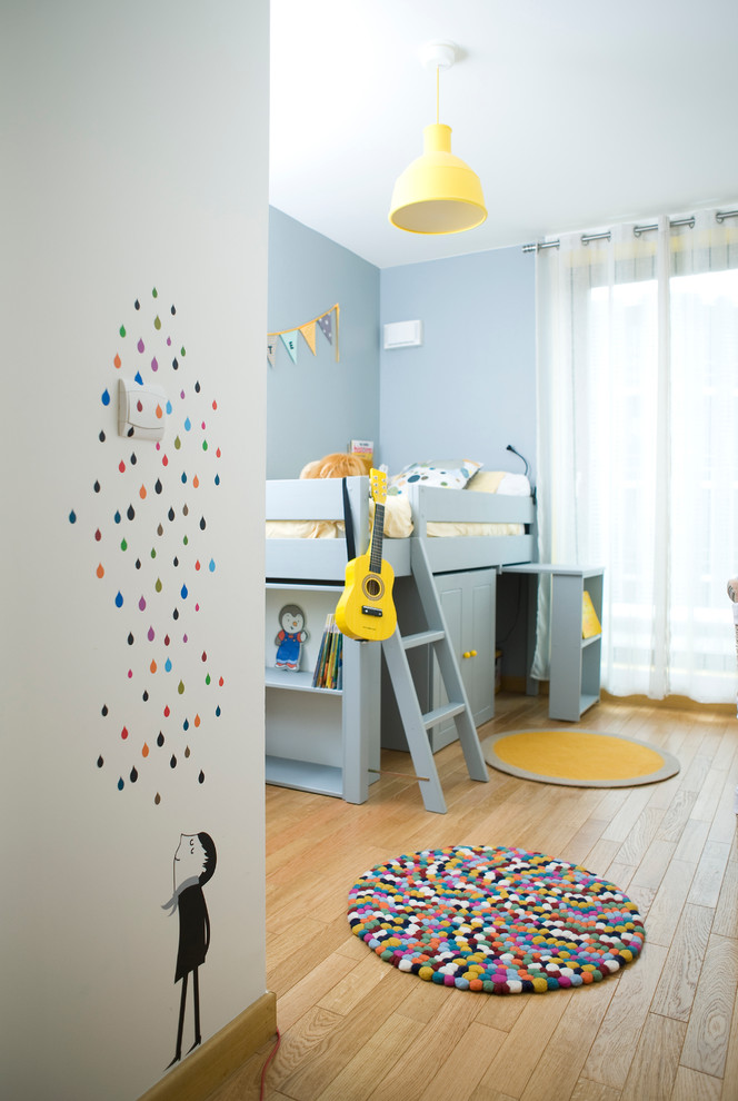 Idéer för mellanstora funkis könsneutrala barnrum kombinerat med sovrum och för 4-10-åringar, med ljust trägolv och blå väggar