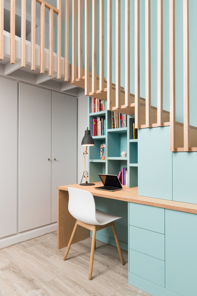Inspiration för små moderna könsneutrala tonårsrum kombinerat med skrivbord, med blå väggar, ljust trägolv och beiget golv