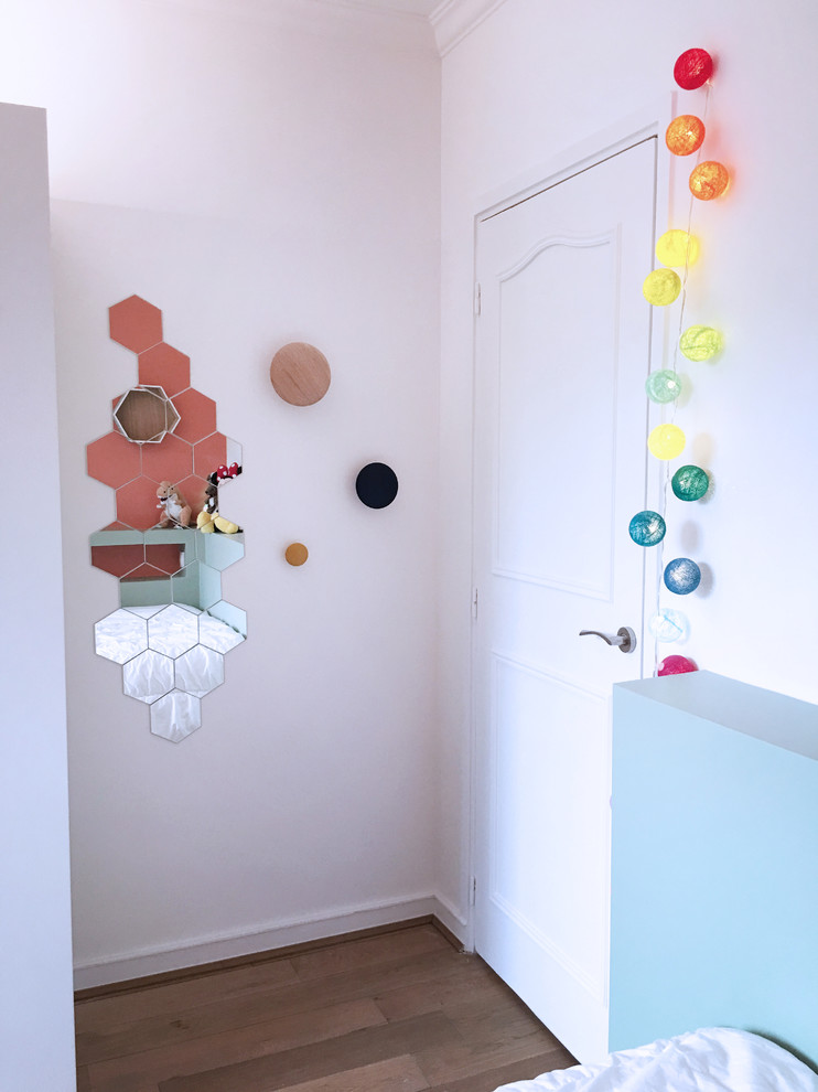 Idées déco pour une chambre d'enfant contemporaine de taille moyenne avec un mur rose, parquet clair et un sol marron.