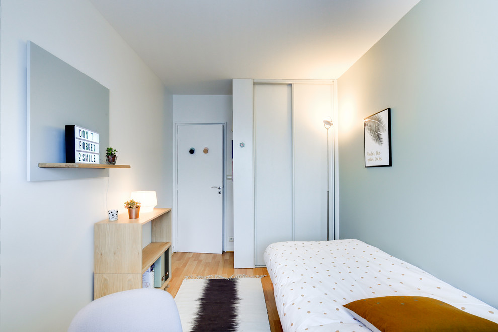 Réalisation d'une chambre d'enfant nordique de taille moyenne avec un mur vert, parquet clair et un sol beige.
