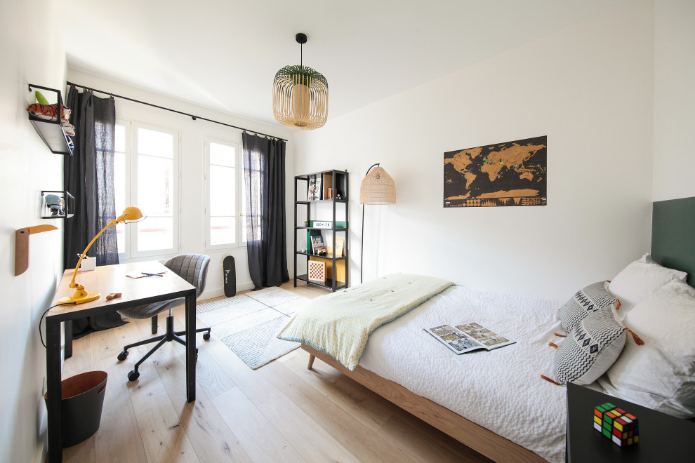 Imagen de dormitorio infantil escandinavo de tamaño medio con escritorio, paredes verdes y suelo de madera clara