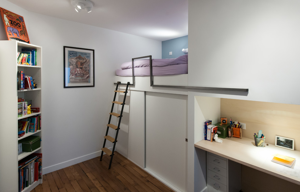 Idée de décoration pour une petite chambre d'enfant design avec un mur bleu et un sol en bois brun.