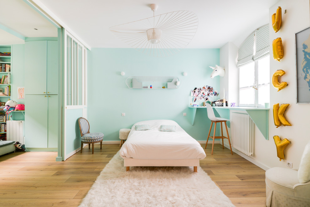Idées déco pour une chambre d'enfant éclectique avec un mur vert, un sol en bois brun et un sol marron.