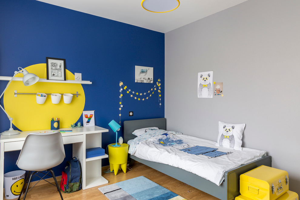 Foto di una cameretta per bambini da 4 a 10 anni design di medie dimensioni con pavimento in legno massello medio e pareti multicolore