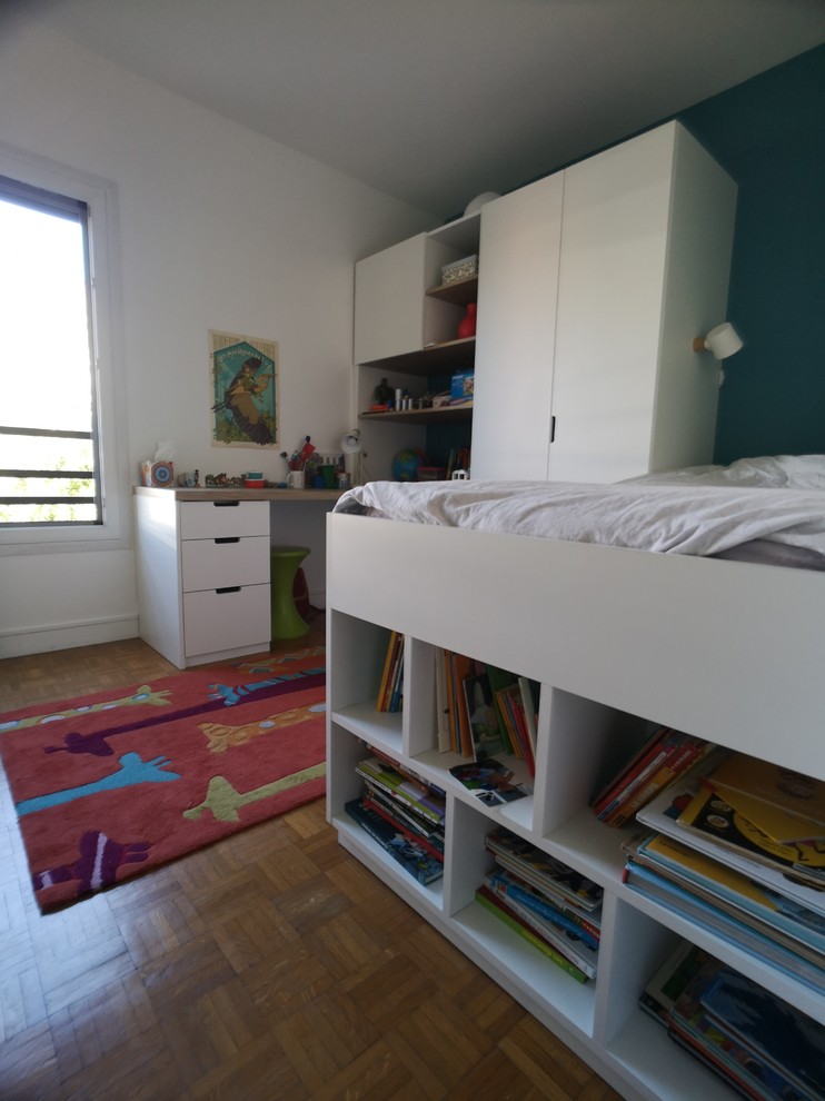 Modelo de dormitorio infantil de 4 a 10 años contemporáneo pequeño con paredes azules y suelo de madera clara