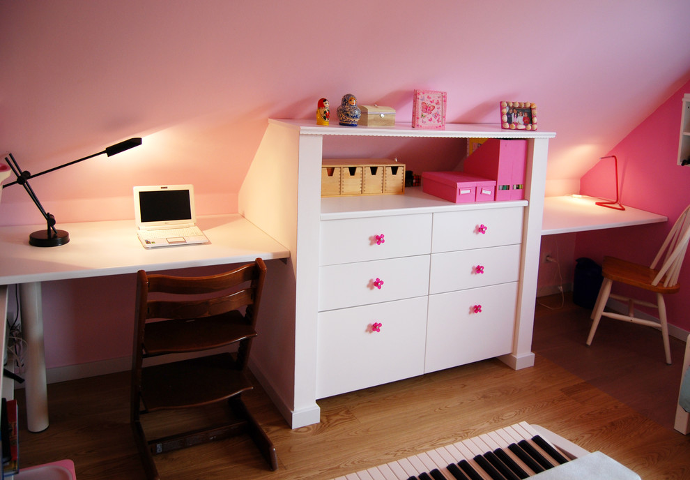 Imagen de habitación de niña de 4 a 10 años romántica de tamaño medio con escritorio, paredes rosas, suelo de madera clara y suelo beige