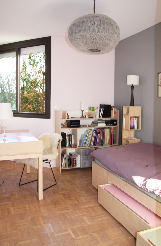Foto på ett litet minimalistiskt könsneutralt tonårsrum kombinerat med sovrum, med grå väggar, brunt golv och mellanmörkt trägolv